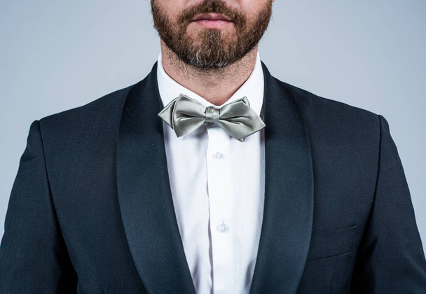 Bachelor with unshaven face cropped view wear elegant tuxedo with silver bow tie grey background, formal - Фото, изображение