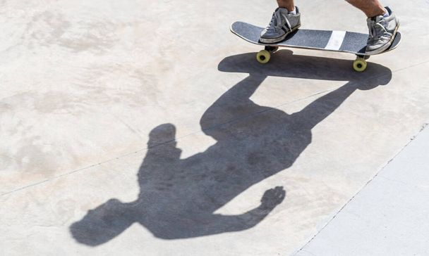 Молодой мужчина едет на скейтборде - Фото, изображение