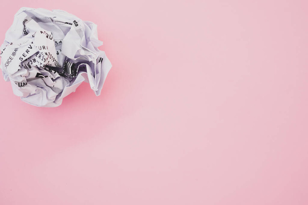A high angle shot of a wrapped paper ball isolated on a pink background - Photo, image