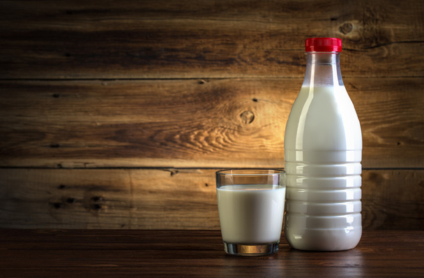 стекло и бутылка молока на деревянном фоне
 - Фото, изображение