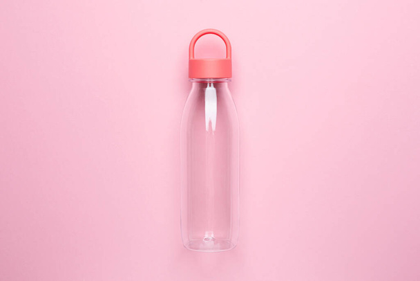 Transparent water bottle on a pink background, for jogging and sports top view - Фото, зображення