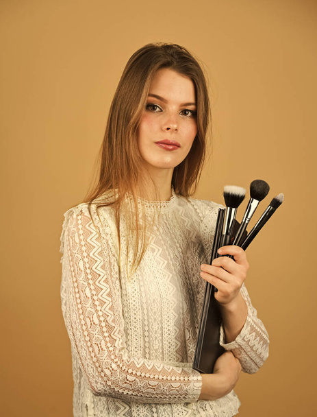 Cosmetology, girl with healthy skin. Skin care concept. female fashion style. girl has long hair. makeup and cosmetics. portrait of woman with beauty face. professional visagiste makeup brush - Photo, Image