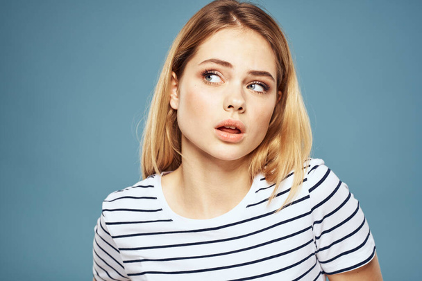 woman wearing striped t-shirt cropped view blue isolated background displeased facial expression - Photo, Image