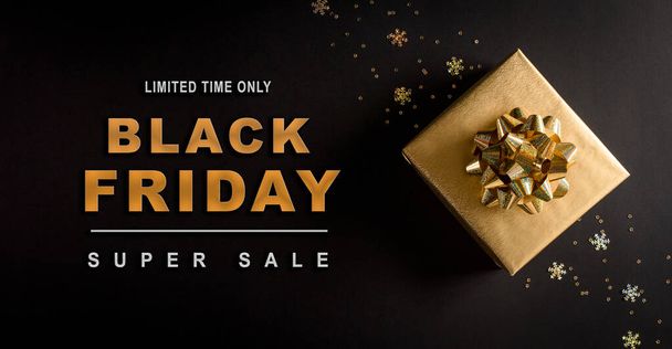 Top view of golden christmas gift boxes on black background with Black Friday text. Black Friday Sale, Banner, poster composition. - Photo, Image