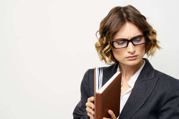 Business woman with notepad and glasses work light background cropped view of suit model. - Фото, зображення