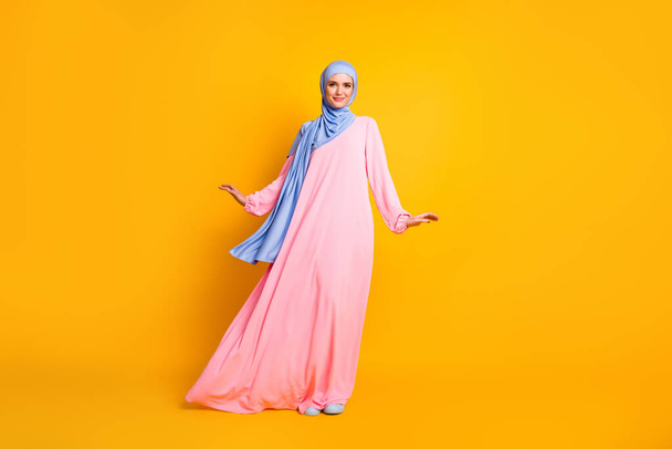 Plná délka tělo velikost pohled na pěkné krásné veselé ženské muslimah na sobě hidžáb šaty představovat izolované lesk žlutá barva pozadí - Fotografie, Obrázek