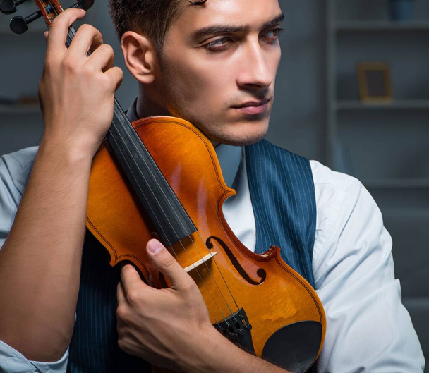 若い音楽家の男は自宅でバイオリンを練習 - 写真・画像