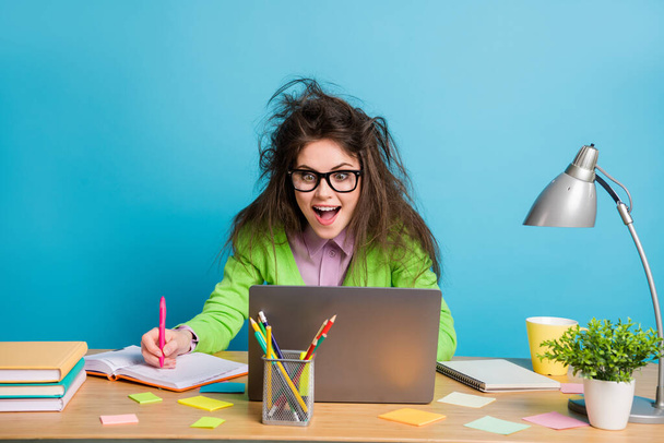 Portrait of her she nice attractive smart clever cheerful girl writing notes watching video tutorial lesson isolated over bright blue color background - Foto, afbeelding