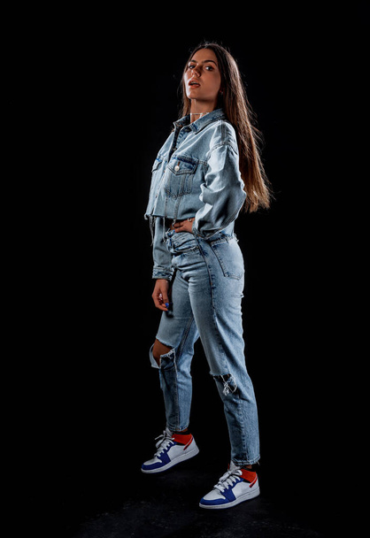 Body shot ενός cool σύγχρονου κοριτσιού που φοράει crop denim σακάκι και blue jeans - Φωτογραφία, εικόνα