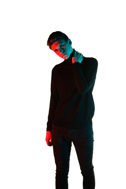 Stijlvolle fashion guy draagt trendy zwarte trui en zwarte jeans - Foto, afbeelding