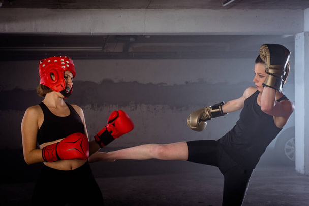 Esportista forte fazendo seu chute de perna alta em seu amigo boxeador feminino - Foto, Imagem