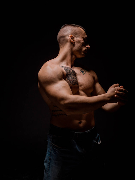 Svalnatý mladý fitness sportovní muž cvičení s činkou ve fitness tělocvičně - Fotografie, Obrázek