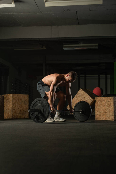 Fit strong shirtless athlete doing squats. Hardcore Cross-fit workout concept. - Fotografie, Obrázek