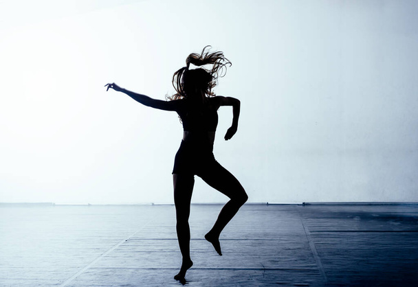 Knappe jonge vrouw die een eigentijdse ballet routine uitvoert - Foto, afbeelding