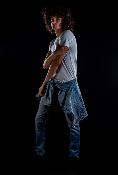 Studio fashion portrait of a rock boy wearing blue jeans and white t-shirt - Фото, изображение