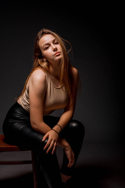 Portrait of an attractive stylish woman posing against black background - Photo, Image