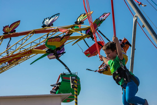 Fun milující chlapec skákání na trampolíně na místním karnevalu - Fotografie, Obrázek