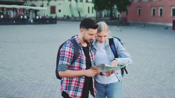 Чоловік і жінка тримають карту і шукають якесь місце на міській площі
 - Кадри, відео