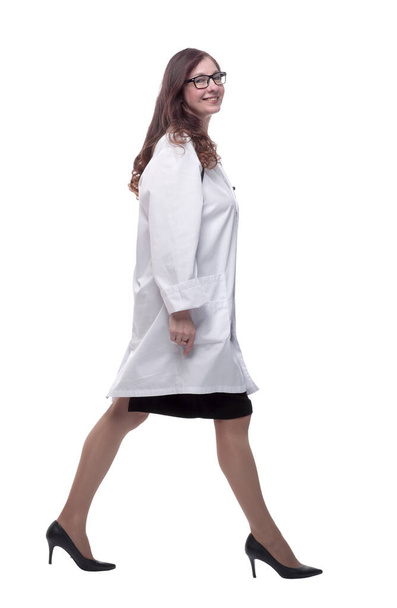 side view. a smiling woman doctor striding forward - Foto, Bild