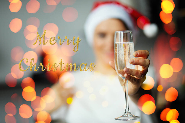 Woman in New Year's cap with a glass of champagne, Christmas holiday and fun - Photo, Image