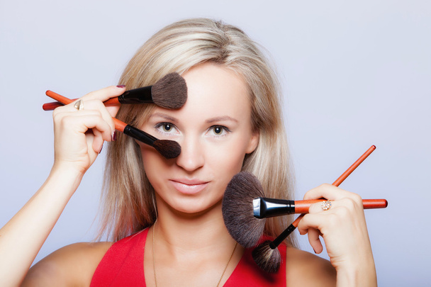  Beauty procedures, woman holds make-up brushes near face. - Foto, imagen