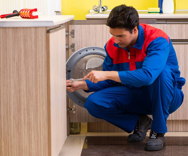 Reparateur repariert Waschmaschine in der Küche - Foto, Bild