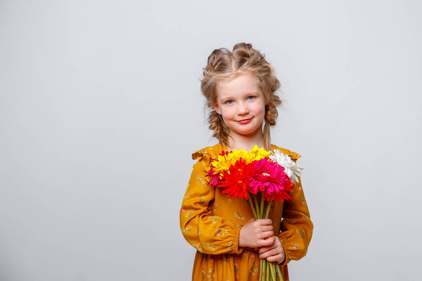 portré egy gyönyörű lány egy csokor virág egy fehér háttér - Fotó, kép