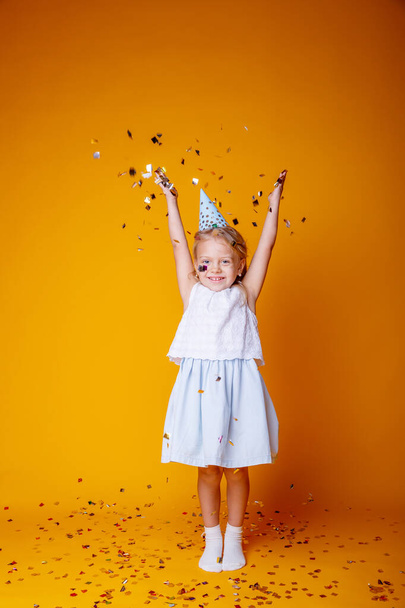 Lustiges Geburtstagskind posiert vor orangefarbenem Hintergrund und macht Mimik  - Foto, Bild