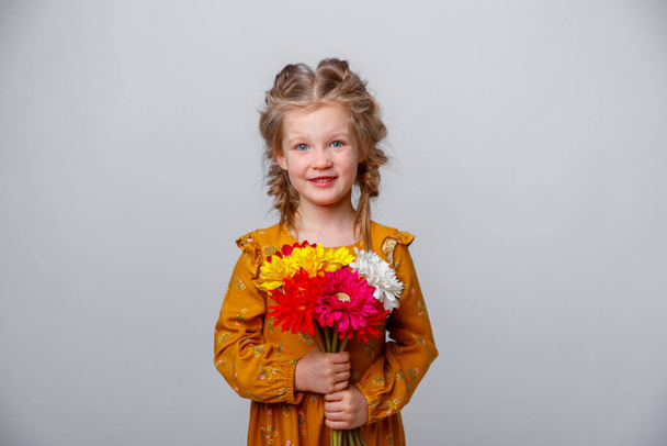 portret van schattig meisje houden boeket van de lente bloemen op witte achtergrond  - Foto, afbeelding