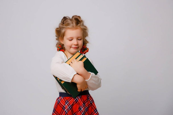 child girl in school uniform  hold book white background  - Fotografie, Obrázek