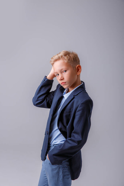 ritratto di un ragazzo in giacca e cravatta su sfondo grigio - Foto, immagini