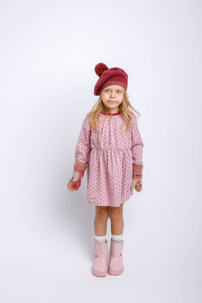 adorable little girl posing in winter clothes against gray  - Zdjęcie, obraz