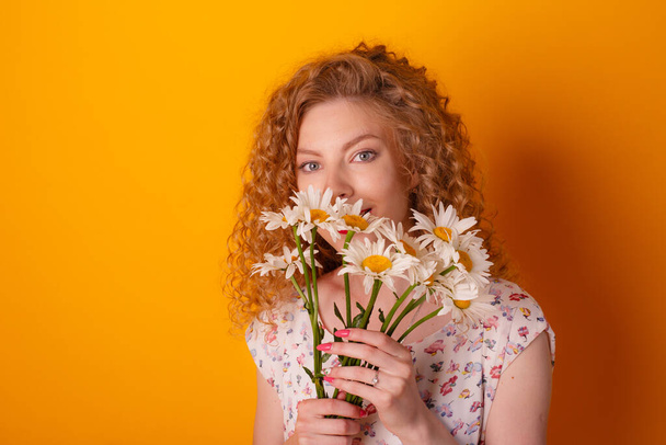 girl with a bouquet of daisies on a orange background - Photo, Image
