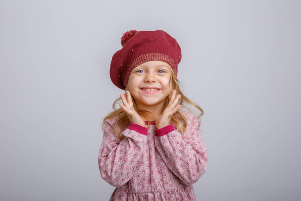 adorable little girl posing in winter clothes against gray  - Fotografie, Obrázek