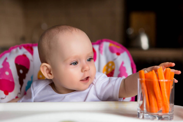roztomilé malé dítě s jídlem v barevné dětské křeslo - Fotografie, Obrázek