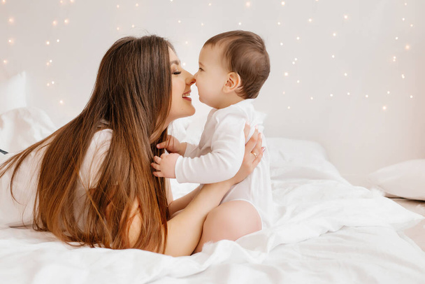 gelukkig jong mam knuffels peuter in bed - Foto, afbeelding