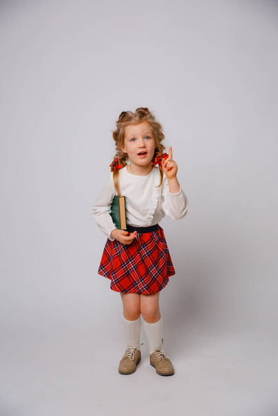 child girl in school uniform  hold book white background  - Fotoğraf, Görsel