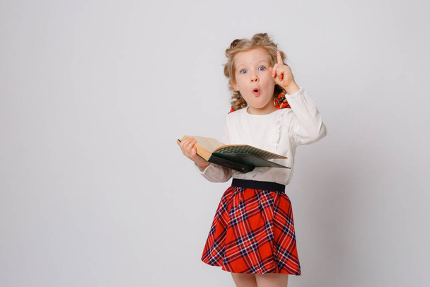 child girl in school uniform  hold book show idea on white background  - Фото, изображение