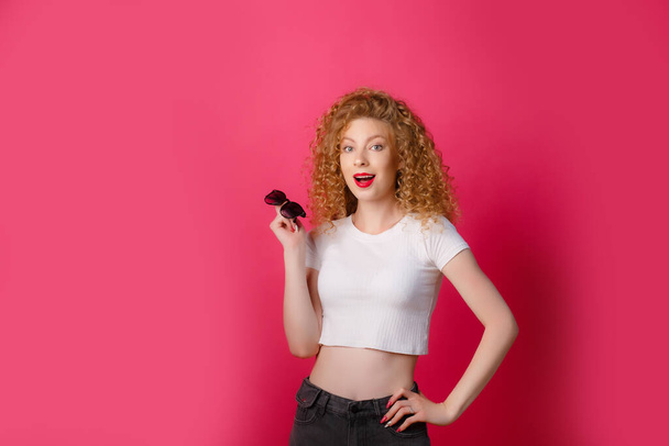 beautiful ginger girl posing on the pink background   - 写真・画像