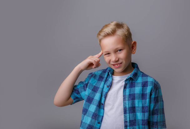 portrait of a cute boy in a t-shirt on a gray background - Fotografie, Obrázek