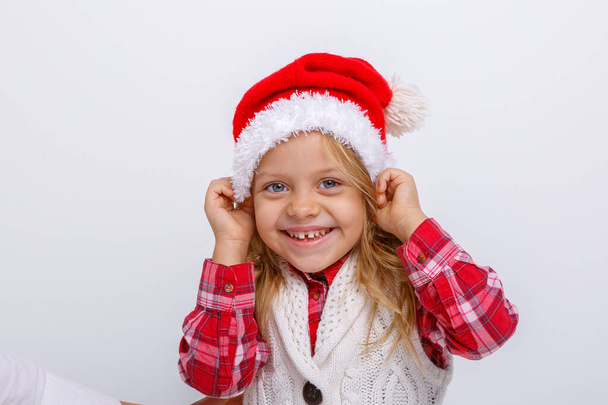 χαριτωμένο κορίτσι ποζάρουν στο καπέλο santa κατά γκρι  - Φωτογραφία, εικόνα