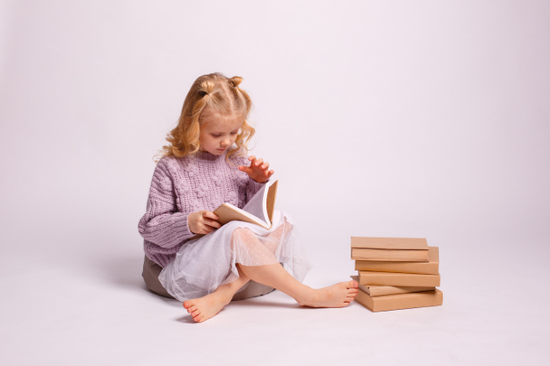 schattig meisje lezen boek, zitten op de vloer  - Foto, afbeelding