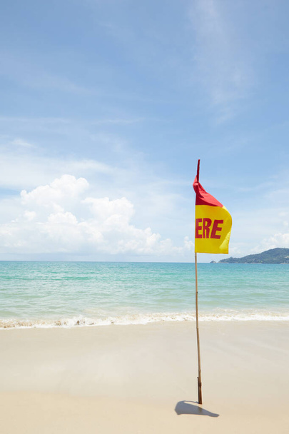 Προβολή προειδοποιητικής σημαίας σε ωραία ζεστή τροπική παραλία κατά τη διάρκεια της νομικής περιόδου - Φωτογραφία, εικόνα
