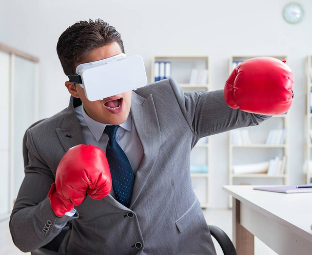 Ο άνθρωπος πυγμαχία στο γραφείο με γυαλιά εικονικής πραγματικότητας - Φωτογραφία, εικόνα