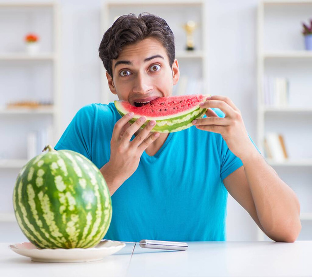 Mies syö vesimelonia kotona - Valokuva, kuva