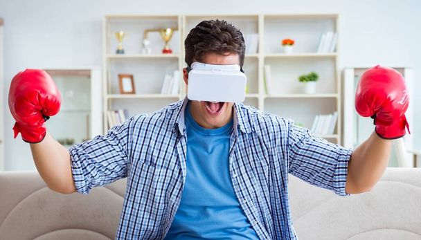 Man wearing virtual reality VR glasses playing boxing game - Valokuva, kuva