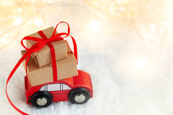 Christmas toy truck with gift boxes and pine tree on wooden table over green background. Holiday greeting card. - Φωτογραφία, εικόνα