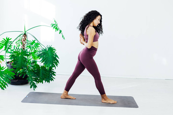 Красивая женщина yoga гимнастика гибкая растягивая asana фитнес белая комната - Фото, изображение
