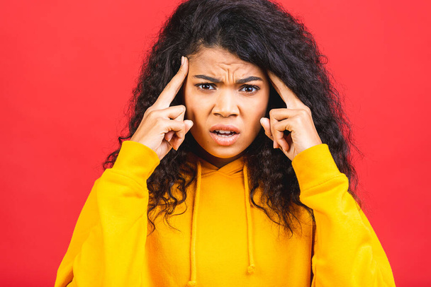 Mujer africana nerviosa respirando calmándose aliviando el dolor de cabeza o manejando el estrés, chica negra sintiéndose estresada masajeando las sienes exhalando aislada sobre fondo rojo. - Foto, Imagen
