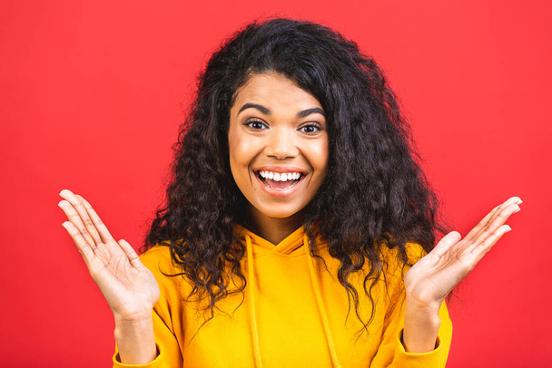 Surprised shocked amazed beautiful curly black african american woman isolated over red background. - Φωτογραφία, εικόνα